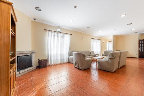a living room with chairs and a tv and a fireplace at O Pimpao in Geres