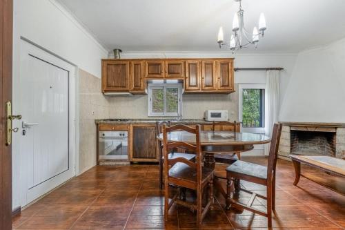 a kitchen with wooden cabinets and a table with chairs at O Pimpao in Geres