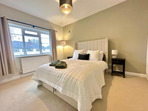 a bedroom with a white bed and a window at Lovely spacious 3 double bed flat, LS17 in Leeds