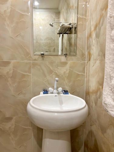 a bathroom with a white sink and a mirror at Babar House in Faisalabad