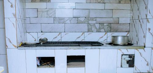 a kitchen with a stove with a pot on it at Empire Motel in Kigali