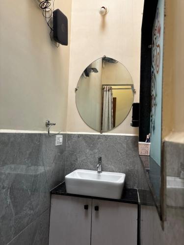 a bathroom with a sink and a mirror at Swastik Home stay in Ujjain