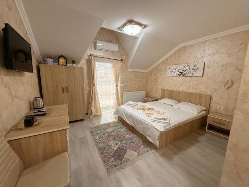 una camera da letto con un letto, una scrivania e una televisione di Casa Bella a Medgidia