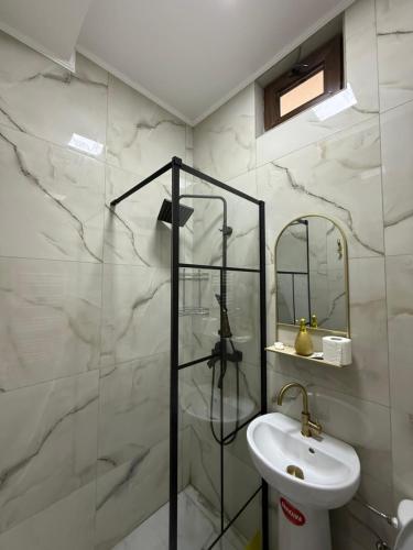 un bagno con lavandino e doccia in vetro di Casa Bella a Medgidia