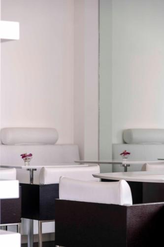 a room with white tables and white chairs at Hotel Exclusive in Agrigento