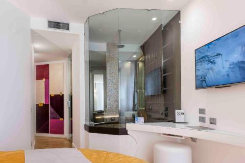 a bathroom with a large mirror and a sink in a room at Hotel Exclusive in Agrigento