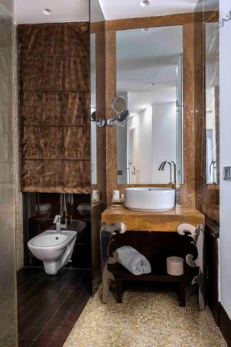 a bathroom with a tub and a sink and a toilet at Hotel Exclusive in Agrigento