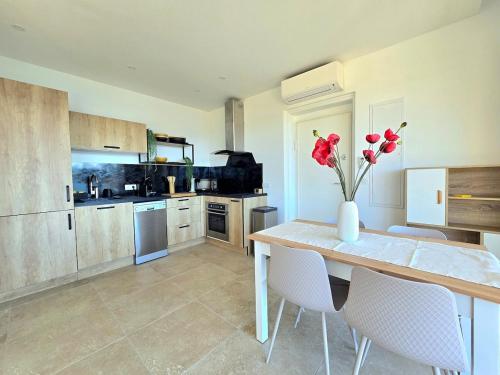 une cuisine avec une table avec un vase de fleurs dessus dans l'établissement Venise1, 4 pers, front de mer, vue étang, clim, à Fréjus