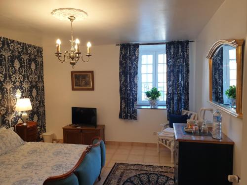 a bedroom with a bed and a desk and windows at Maison St. James in Saint-James