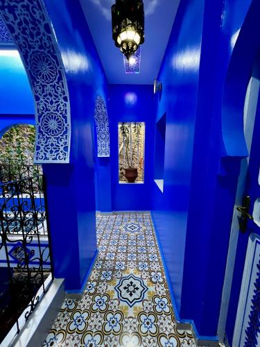 a blue hallway with a tile floor and a chandelier at RIAD CHENGLI 蓝城里 in Chefchaouene