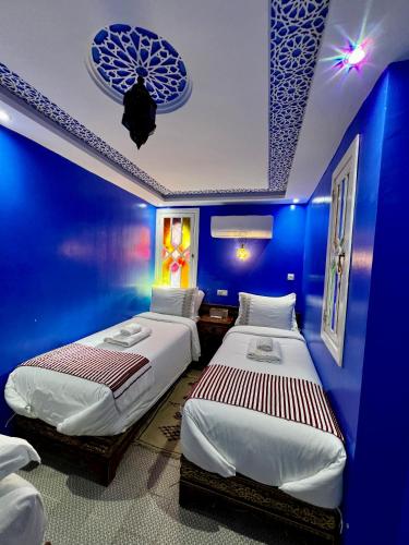 a room with two beds in a blue room at RIAD CHENGLI 蓝城里 in Chefchaouene
