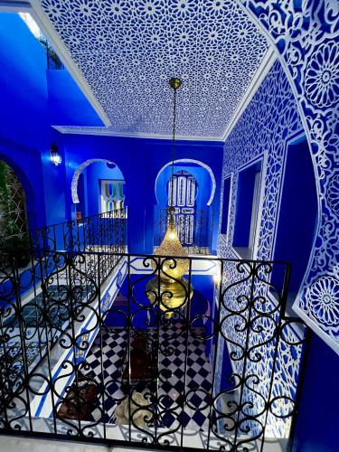 a blue room with a chandelier and a blue ceiling at RIAD CHENGLI 蓝城里 in Chefchaouene