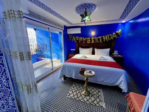 a bedroom with a happy birthday sign on the bed at RIAD CHENGLI 蓝城里 in Chefchaouene