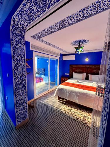 a blue bedroom with a bed and a window at RIAD CHENGLI 蓝城里 in Chefchaouene