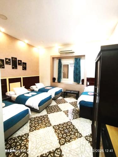 a hotel room with four beds in a room at the Hotel Emerald in Cairo