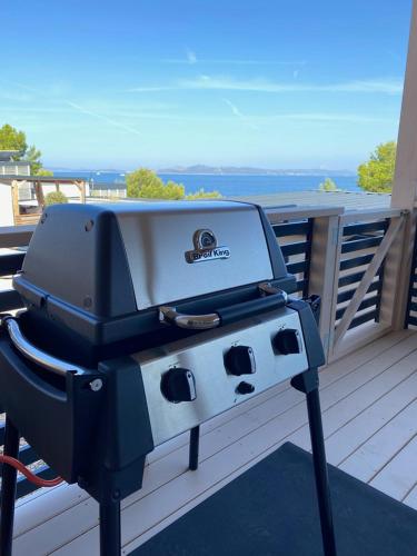 a grill sitting on a deck with the ocean in the background at Perferct Day Mobile Home in Drage