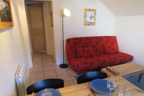 a living room with a red couch and a table at Le Bachasson in Névache