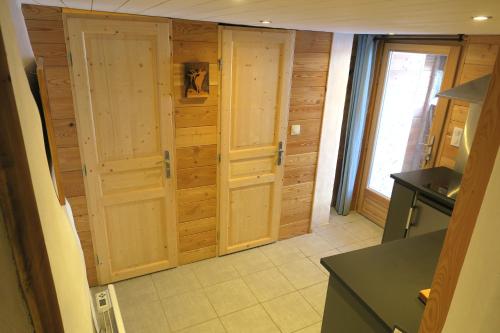 a kitchen with two wooden doors in a room at Le Bachasson in Névache