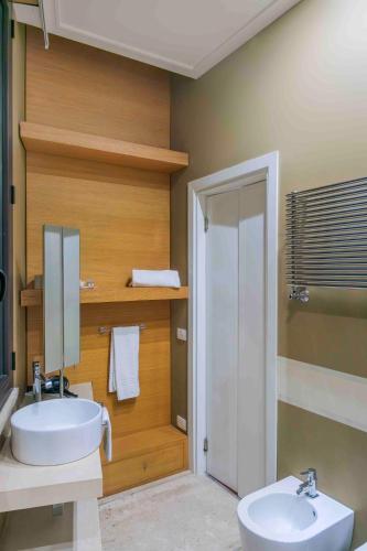 a bathroom with a sink and a toilet and a mirror at Hotel Exclusive in Agrigento