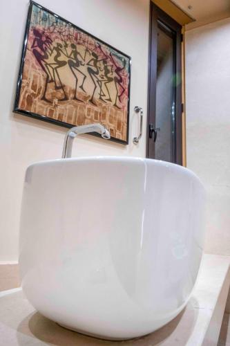 a white bath tub sitting on a counter in a bathroom at Hotel Exclusive in Agrigento