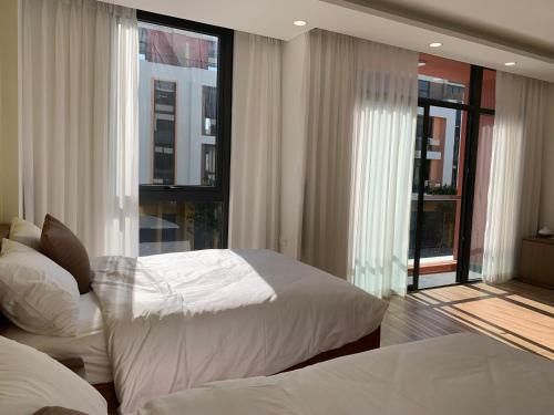 富国Mey lnn Hotel Phu Quoc Island的带两张床和大窗户的卧室