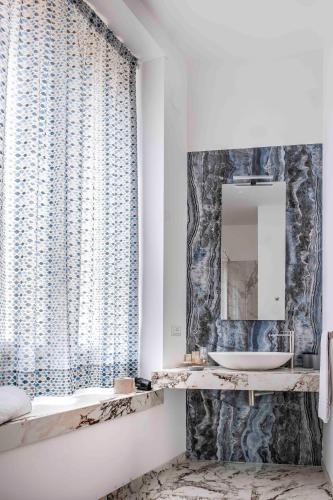 a bathroom with a sink and a mirror at Hotel Exclusive in Agrigento