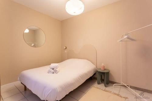 une chambre avec un lit blanc et un miroir dans l'établissement Le Loft du Midi - Full Centre, à Saint-Gaudens