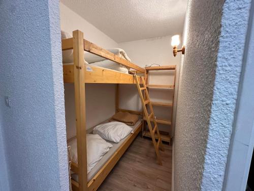 une chambre avec deux lits superposés et une échelle dans l'établissement Studio cosy au pied des pistes, parfait pour famille, avec balcon, proche golf et randonnées - FR-1-515-99, à Corrençon-en-Vercors