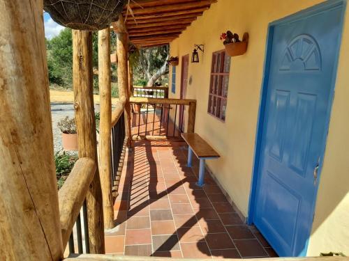 a porch with a blue door and a bench at Cabaña Umpalita para 4 cuatro personas in Los Santos
