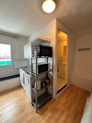 une petite cuisine avec un micro-ondes et un réfrigérateur dans l'établissement Le gite 