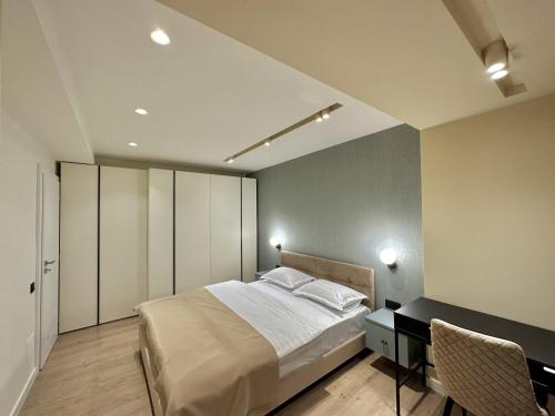 a bedroom with a bed and a desk in it at Deluxe Aparthotel Central in Zalău