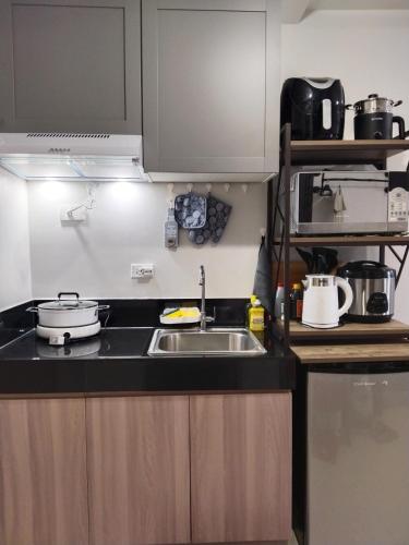 a kitchen with a sink and a counter top at E214 Place at SMDC Cheer Residences in Marilao