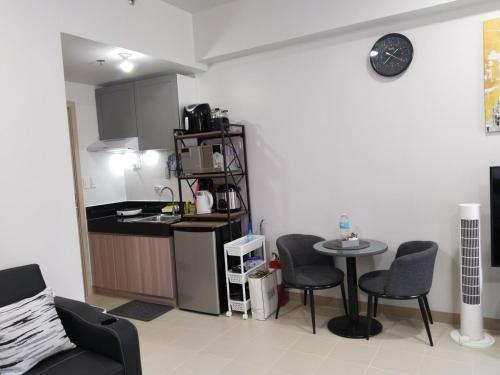a kitchen and a living room with a table and chairs at E214 Place at SMDC Cheer Residences in Marilao