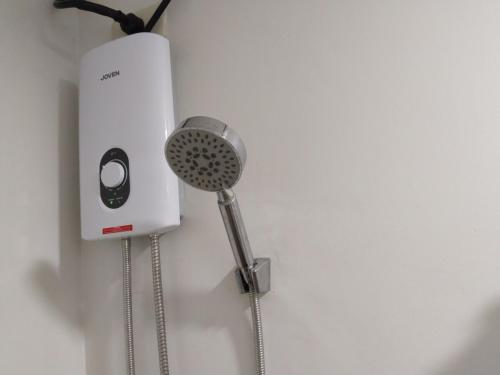 a shower head and a hair dryer on a wall at E214 Place at SMDC Cheer Residences in Marilao
