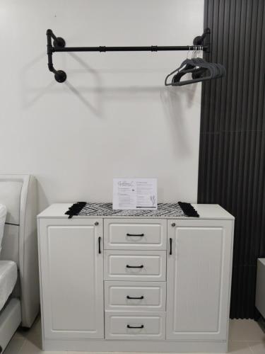 a white dresser with a lamp on top of it at E214 Place at SMDC Cheer Residences in Marilao