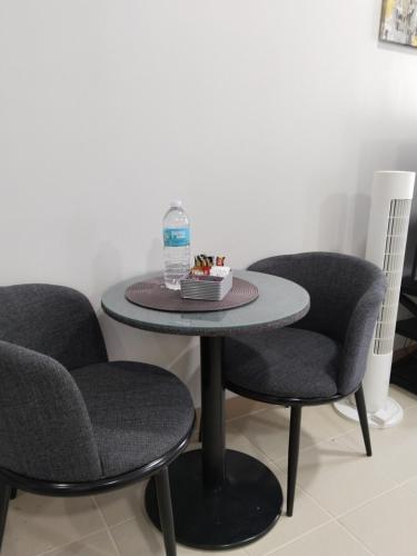 a table with two chairs and a bottle of water on it at E214 Place at SMDC Cheer Residences in Marilao