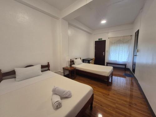 two beds in a room with wooden floors at Cool Breeze Lodge and Cafe in Banaue