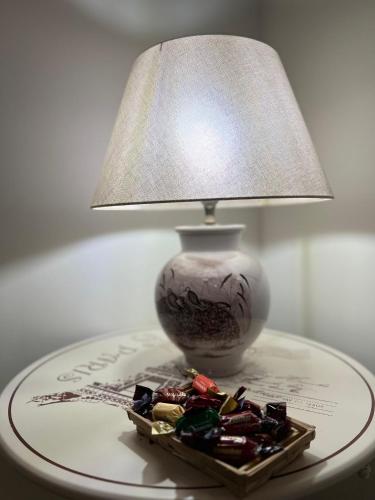 a table with a lamp and a plate of candies at Rhome country lodge in La Massimina-Casal Lumbroso