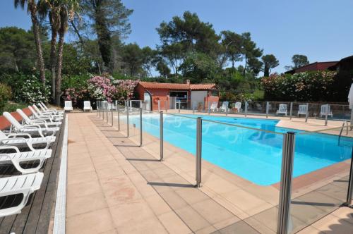 - une piscine bordée de chaises longues blanches dans l'établissement Appt Hôtel Albatros, Parking, Balcon, Piscine, proche Golf St Donat, à Mouans-Sartoux