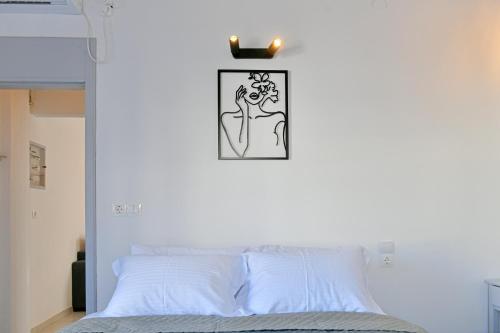 a bed with a black and white picture on the wall at Aori Guest House I in Hydra