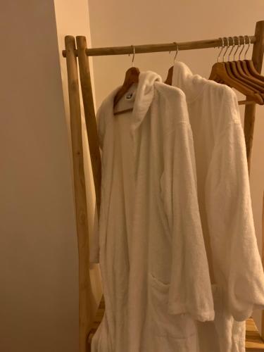 a group of white shirts hanging on a rack at Gîte 4 étoiles - Sauna & Balnéo jacuzzi privatifs in Orléans