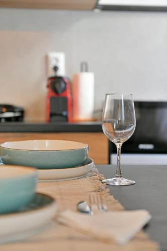 a table with plates and a glass of wine on it at Aori Guest House I in Hydra