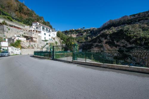 a fence on the side of a mountain with a building at Terrace Belvedere suite- Amalfi coast - free park- Pontone -Scala in Pontone