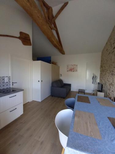 une cuisine et un salon avec une table et un canapé dans l'établissement Gîte la petite maison, à Montournais
