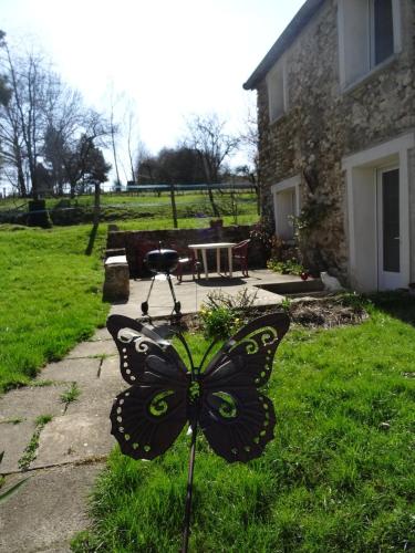 a butterfly sculpture in the yard of a house at Moulin de la Ville Chamblon en Pleine nature parmi les chevaux proche château thierry in Montfaucon