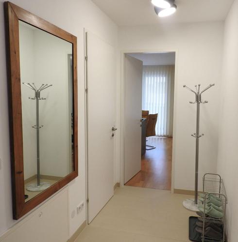 a mirror on a wall in a room with a hallway at Wien Schwechat Apartment Airport in Schwechat