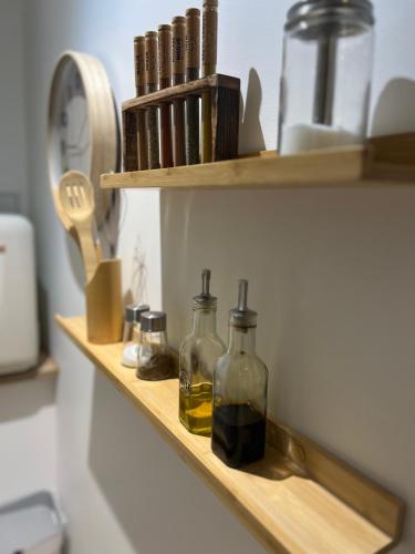 - une étagère en bois avec deux bouteilles d'huile dans l'établissement Gîte 4 étoiles - Sauna & Balnéo jacuzzi privatifs, à Orléans