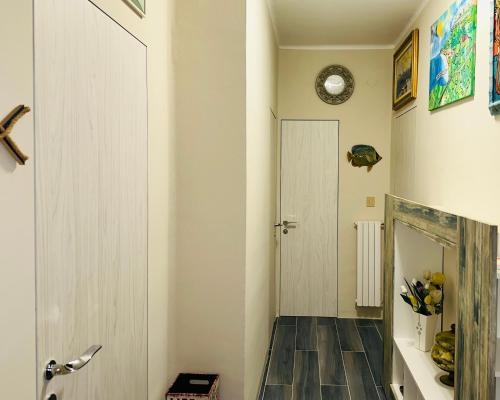 a hallway with a white door and a wooden floor at Maison Elsa in San Vito Chietino