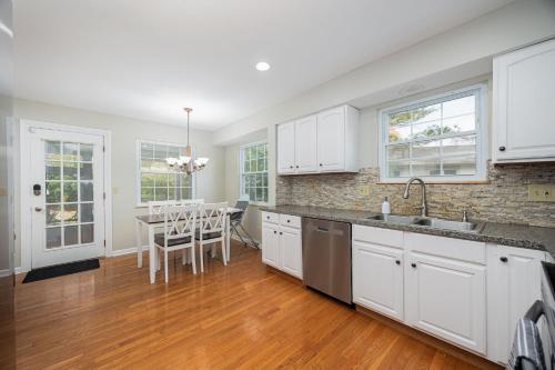 a kitchen with white cabinets and a table with chairs at Spacious Columbus Retreat Activities and Games Galore in Columbus