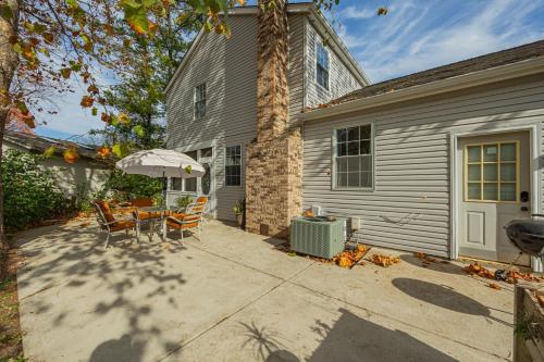 a patio with a table and an umbrella in front of a house at Spacious Columbus Retreat Activities and Games Galore in Columbus